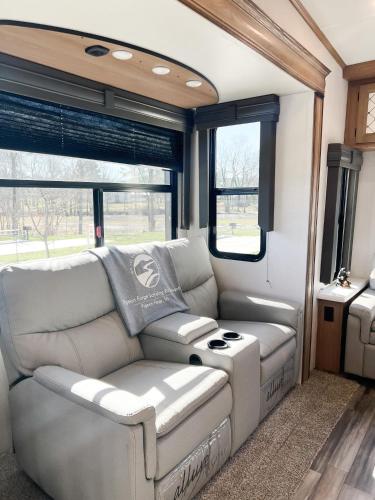 a living room in an rv with a couch and windows at Pigeon Forge Landing RV Resort in Pigeon Forge