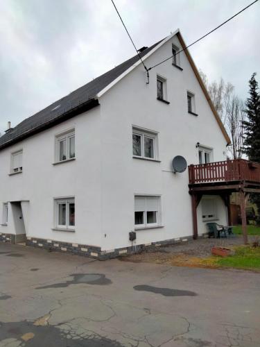 Cette maison blanche dispose d'un balcon sur le côté. dans l'établissement Haus Peter, à Eppendorf