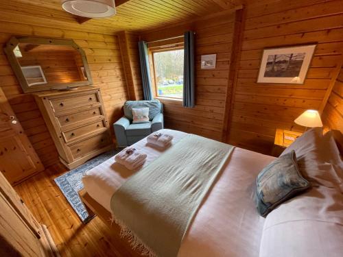 um quarto com uma cama num chalé de madeira em Luxury 3 bedroom, 3 bathroom lodge with hot tub em Llanbedr