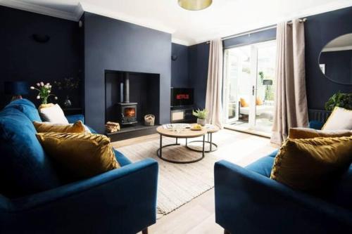 a living room with two blue couches and a fireplace at Large 5 Bedroom House - Alnwick in Alnwick