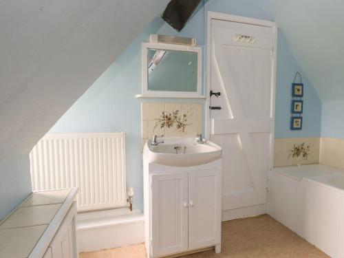 a bathroom with a sink and a mirror at Thatch Cottage in Dorchester