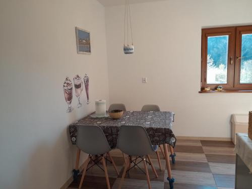 a dining room table with four chairs and a table and a window at Krystyna in Bystre