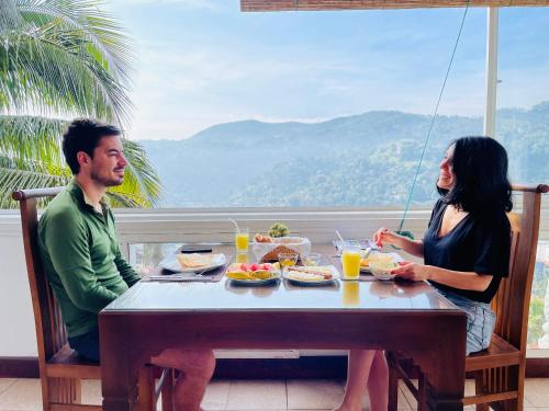 a man and woman sitting at a table eating food at The SkyDeck Kandy in Kandy