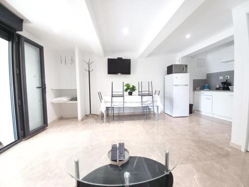 un salon avec une table et une cuisine dans l'établissement Gîte Narbonnais 13 min des plages-Jardin-Terasse-Parking, à Narbonne