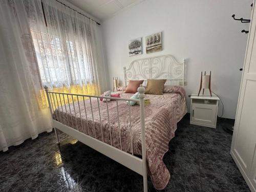 1 dormitorio con 1 cama con marco blanco y ventana en LA SORIANA, en Águilas