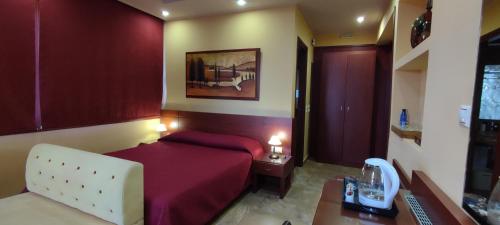 a bedroom with a bed and a desk with a telephone at Villa Koulouridi Agritourism in Daratso