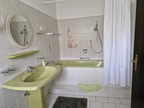 a bathroom with a green sink and a tub at Apartment Schomaker-Fatmann in Werlte