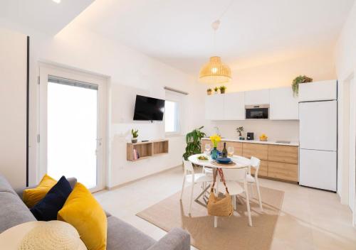 a living room with a table and a kitchen at Coppa Carrubo Residenza in Vieste