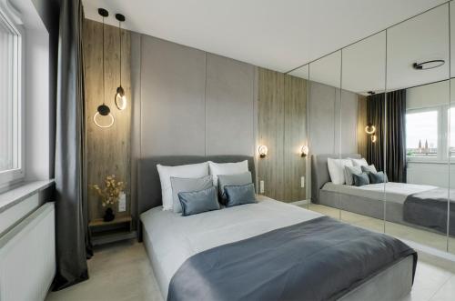 um quarto com uma cama grande e um espelho em SKY Home- Penthouse Sky -Manufaktura, Bezpłatny, Parking, Klimatyzacja, Dostęp na Kod em Lódź