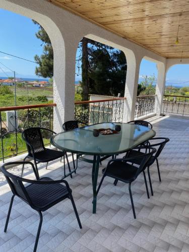 uma mesa de vidro e cadeiras num pátio em Hοme4U em Kallikrateia