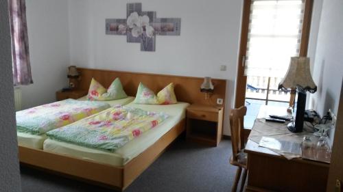 een slaapkamer met een bed, een tafel en een bureau bij Gästehaus Zur Sorge in Pennewitz