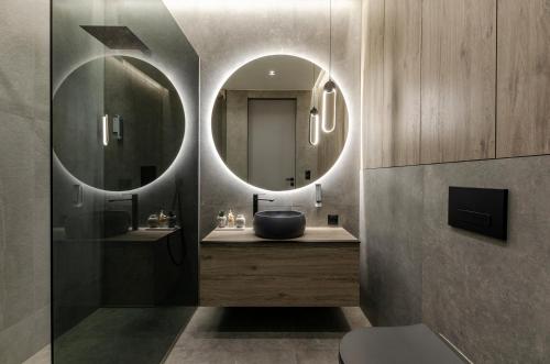 uma casa de banho com um lavatório e um espelho em SKY Home- Penthouse Sky -Manufaktura, Bezpłatny, Parking, Klimatyzacja, Dostęp na Kod em Lódź