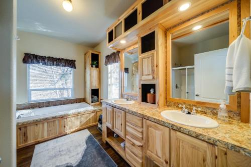 uma casa de banho com armários de madeira, uma banheira e um lavatório. em Newport Riverfront Home with Deck and Fire Pit! em Newport