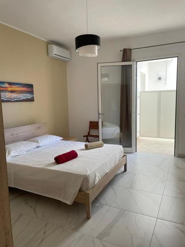 a bedroom with a large bed and a mirror at Camere Lorenzo in Porto Cesareo