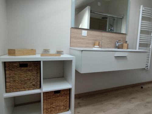 a white bathroom with a sink and a mirror at Les Tilleuls de Marie in Saint-Edmond