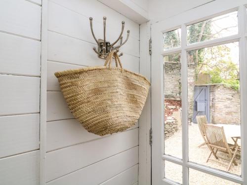 a wicker basket hanging on a wall next to a door at West Island in Kingsbridge