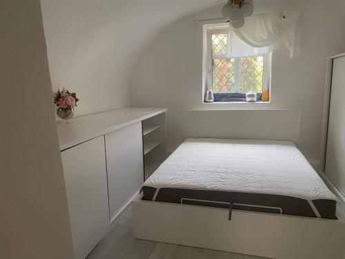 Habitación pequeña con cama y ventana en Apartman Fabrik, en Hainburg an der Donau