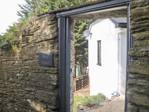 a door to a stone building with a sign on it at West Island in Kingsbridge