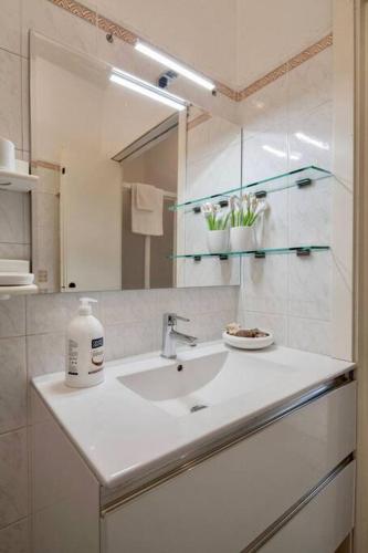 a white bathroom with a sink and a mirror at Casa Nonna in Riomaggiore