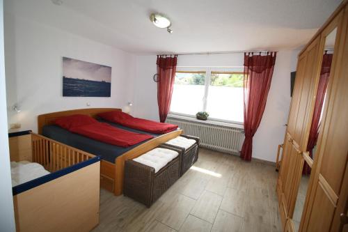 1 dormitorio con cama y ventana en Komfort Ferienwohnung FEWO 74-3 en Bremm