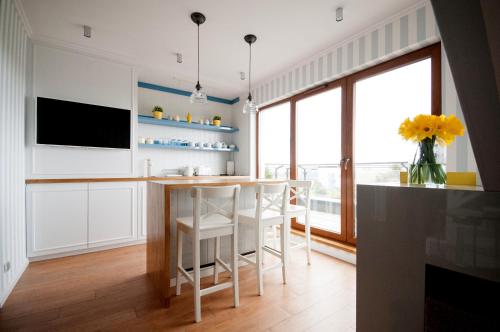 a kitchen with a counter and a table and chairs at Apartament dwupoziomowy Yakima in Puck