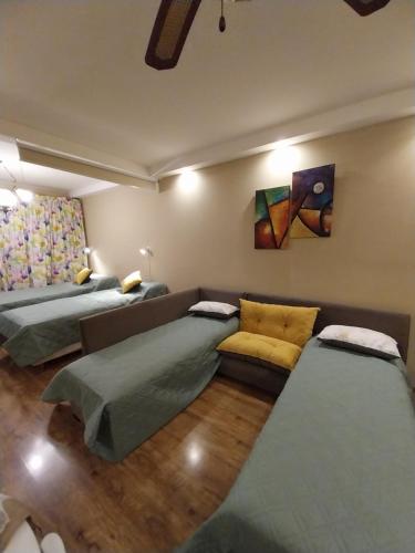 Cette chambre comprend trois lits et un canapé. dans l'établissement EDIFICIO ALVARADO, à Salta