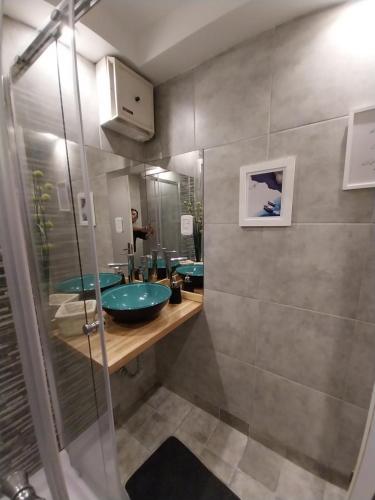 La salle de bains est pourvue de 2 lavabos et d'une douche en verre. dans l'établissement EDIFICIO ALVARADO, à Salta