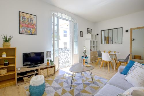 un salon avec un canapé et une télévision dans l'établissement Maison Bianchi - Lamartine, à Nice