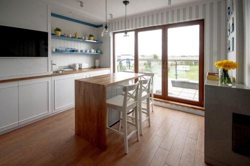 a kitchen with a island with stools and a large window at Apartament dwupoziomowy Yakima in Puck