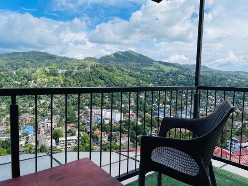 a balcony with a table and chairs overlooking a city at The SkyDeck Kandy in Kandy