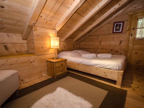 - une chambre dans une cabane en rondins avec un lit et une lampe dans l'établissement Mazot 2 étoiles avec jardin, parking et wifi - Chamonix - FR-1-343-215, à Chamonix-Mont-Blanc