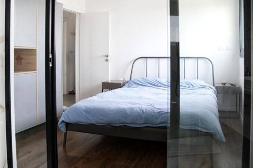 een slaapkamer met een bed met een metalen frame bij A large and well-designed apartment with a stunning view in Or ‘Aqīvāh