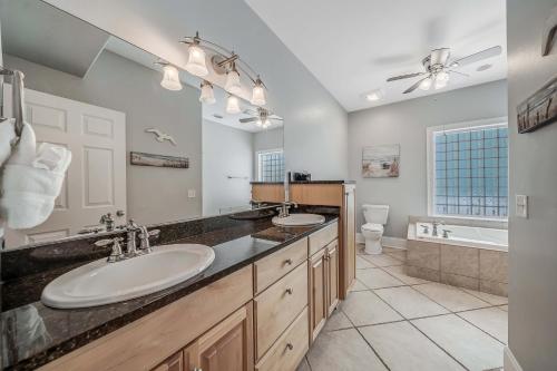 a bathroom with two sinks and a large mirror at Deja Blue by Sand Seeker Vacations in Panama City Beach