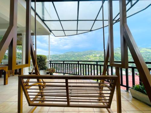 a wooden bench on a balcony with a view at The SkyDeck Kandy in Kandy