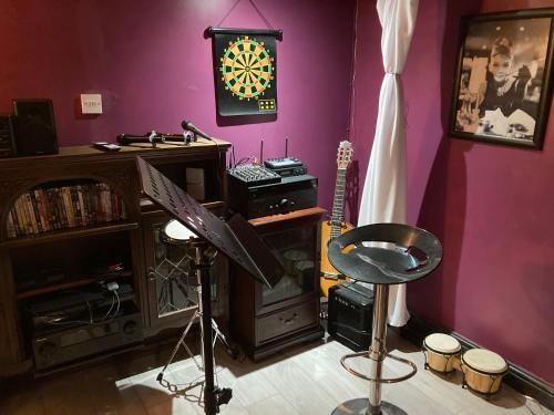 um quarto com uma sala de música com uma bateria e uma guitarra em Jacks Court B5 em Stalybridge