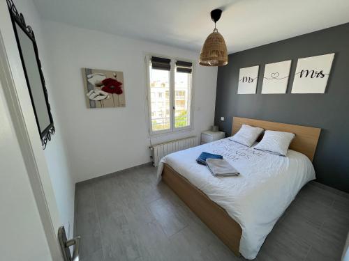 - une chambre dotée d'un lit avec des draps blancs et des murs bleus dans l'établissement Superbe appartement climatisé, 2 chambres à 200m de la plage, au Grau-du-Roi