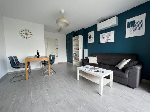 un salon avec un canapé et une table dans l'établissement Superbe appartement climatisé, 2 chambres à 200m de la plage, au Grau-du-Roi