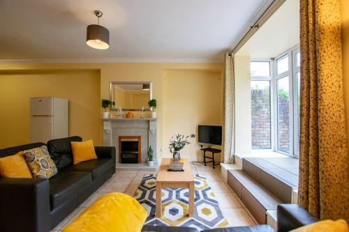 a living room with a black couch and a fireplace at City Center 4 Bedroom Townhouse - Sleeps 8 in Galway