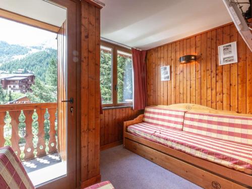 Cette chambre dispose d'un balcon avec un banc et une fenêtre. dans l'établissement Duplex charmant près du centre et des pistes, avec balcon sud, parking et wifi inclus - FR-1-694-39, à Val dʼIsère