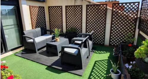 un patio al aire libre con sillas, mesas y plantas en Benicassim SunHouse - Hermoso ático en el Pueblo - Aire acondicionado y BBQ area, en Benicàssim