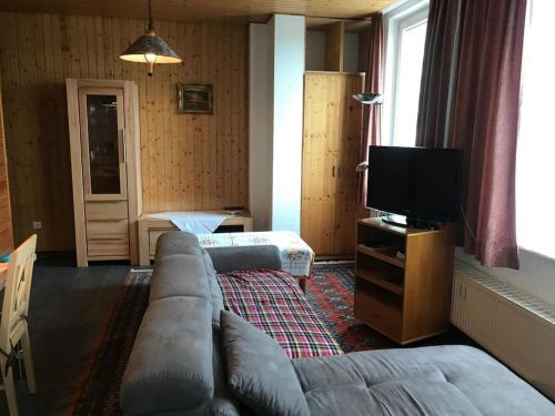 a living room with a couch and a tv at Fewo Cuxhaven/Nordsee in Cuxhaven