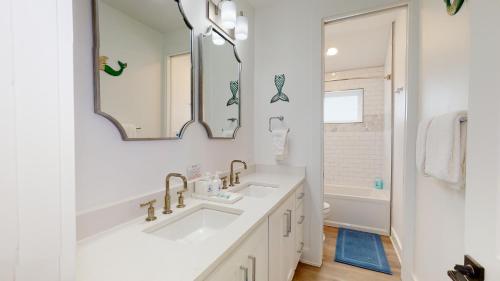 a white bathroom with a sink and a mirror at Dorado Dunes #D Newly Built, Gorgeous Beach Home, Private Pool, Golf Cart Entire Stay in Port Aransas