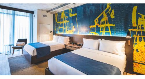 a hotel room with two beds and a chair at Hotel Indigo Tulsa DWTN/Entertainment Area in Tulsa