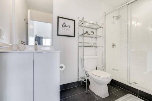 a white bathroom with a toilet and a shower at Waterfront Luxury Condo in Toronto