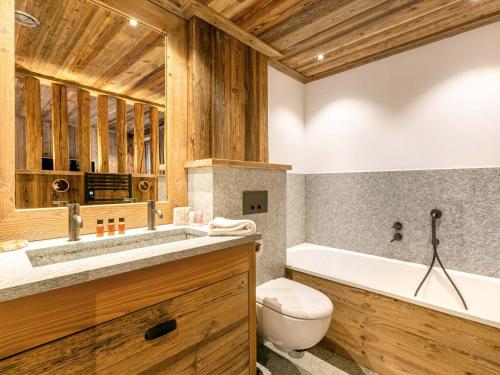 une salle de bain avec une baignoire, des toilettes et un lavabo dans l'établissement Luxueux appartement avec piscine, WiFi et parking à Val-d'Isère - FR-1-694-102, à Val dʼIsère