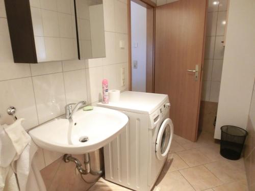 a bathroom with a sink and a washing machine at Haus Peter in Eppendorf