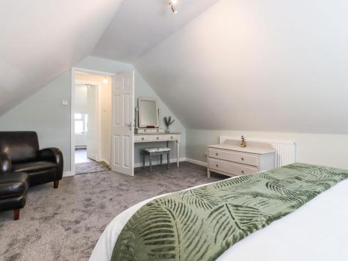 a bedroom with a bed and a chair and a desk at Orchard Retreat in Paddock Wood