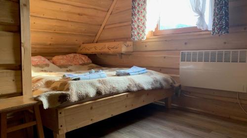 a bedroom with a bed in a log cabin at Domki na wzgórzu in Małe Ciche