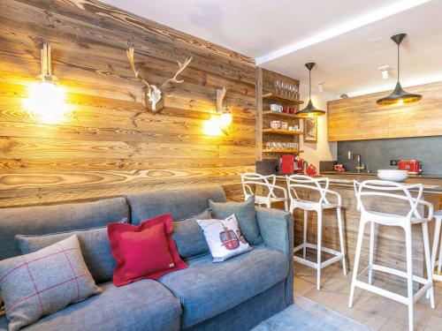 - un salon avec un canapé bleu et un bar dans l'établissement Appartement de prestige au pied des pistes avec wifi, parking couvert, et balcon exposé Est - FR-1-694-153, à Val dʼIsère