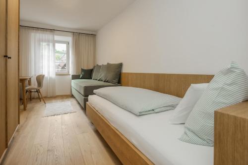 ein Schlafzimmer mit einem Bett und einem Sofa in der Unterkunft Pizzol-hof in Appiano sulla Strada del Vino